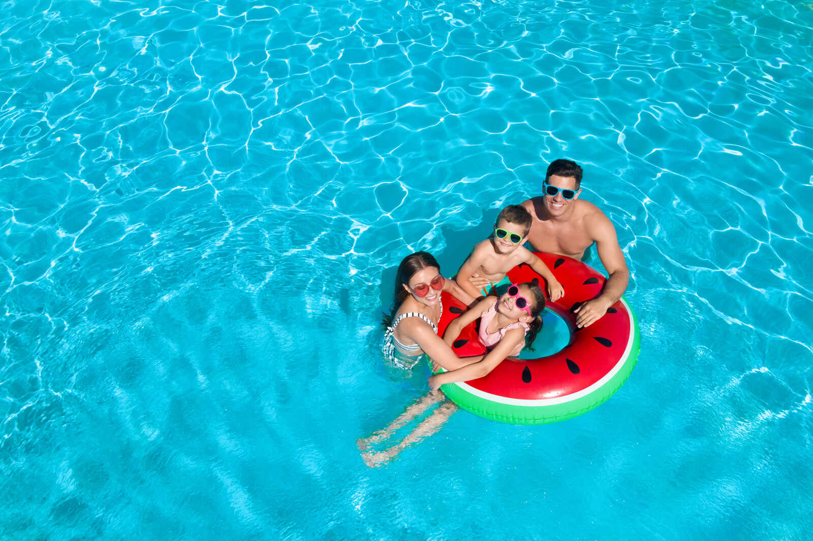 A family in a swimming pool with a floatie