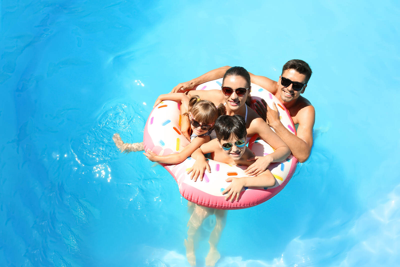 A family in a pool holding an inflatable