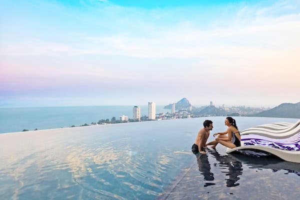 A couple relaxing at Holiday Inn Vana Nava Hua Hin’s pool 