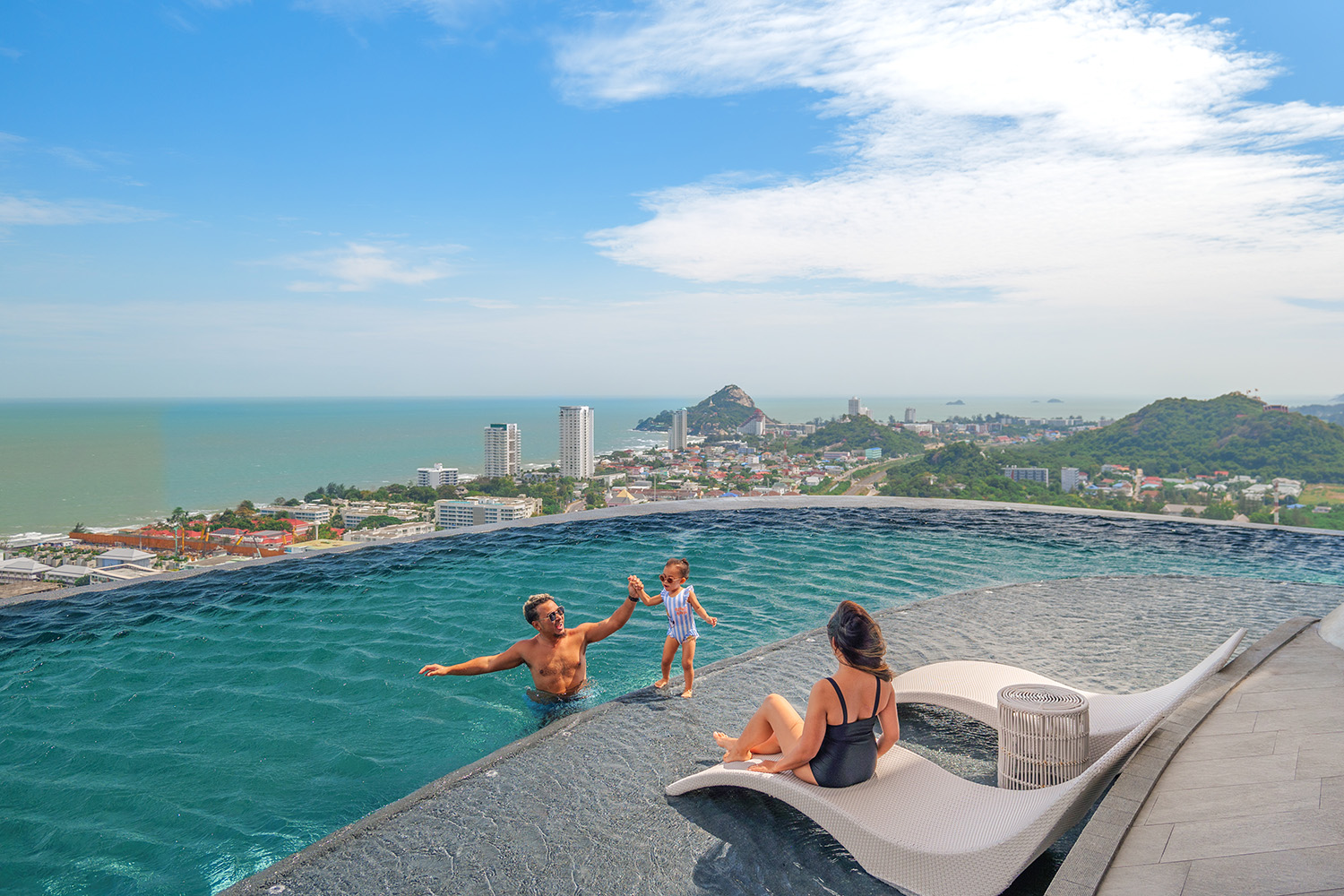 A family enjoying Holiday Inn Vana Nava Hua Hin’s infinity pool